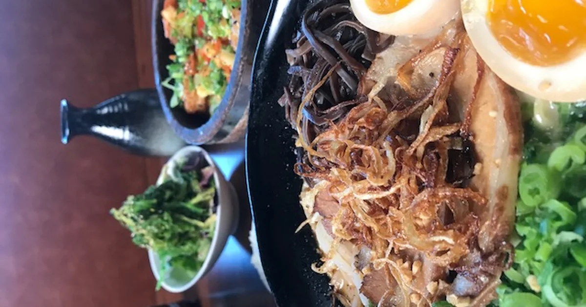A table spread of ramen and side dishes at Bakudan Ramen